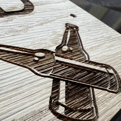 Close-up of crossed cricket-bat clipart engraved in an oak plaque