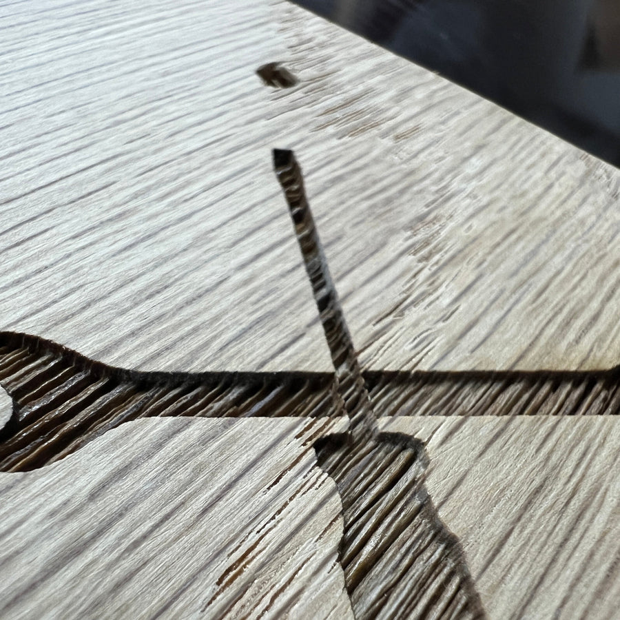 Close-up of crossed-tool clipart engraved in an oak plaque