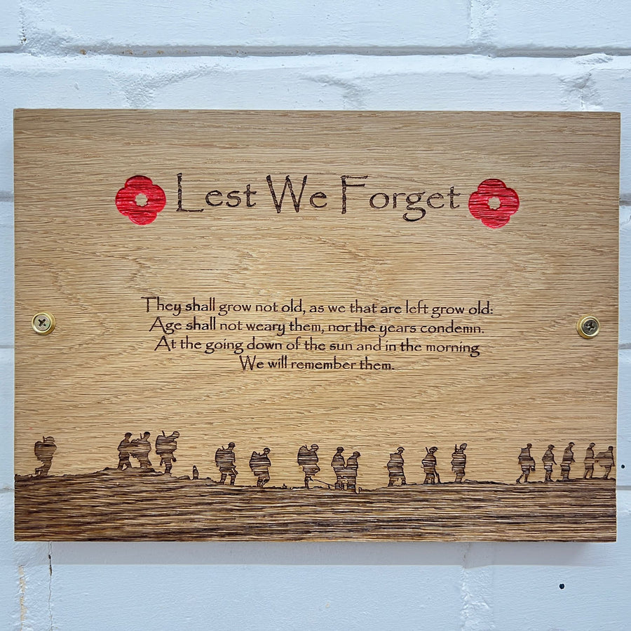 Front view of a Lest We Forget oak plaque with wall fixings