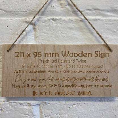 Personalised birch plywood sign hanging by twine against a brick wall