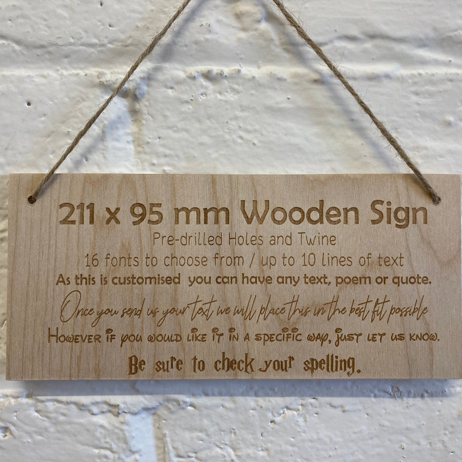 Personalised birch plywood sign hanging by twine against a brick wall