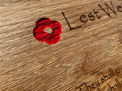Detail of the red poppy decoration on an oak remembrance plaque
