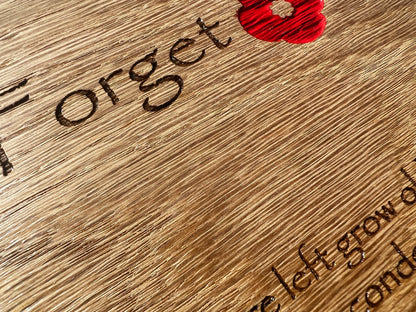 Close-up of engraved remembrance lettering and a red poppy