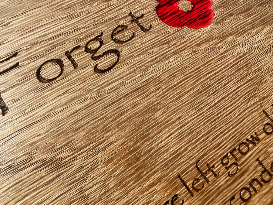 Close-up of engraved remembrance lettering and a red poppy