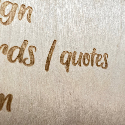 Close-up of engraved script lettering on a large wooden sign