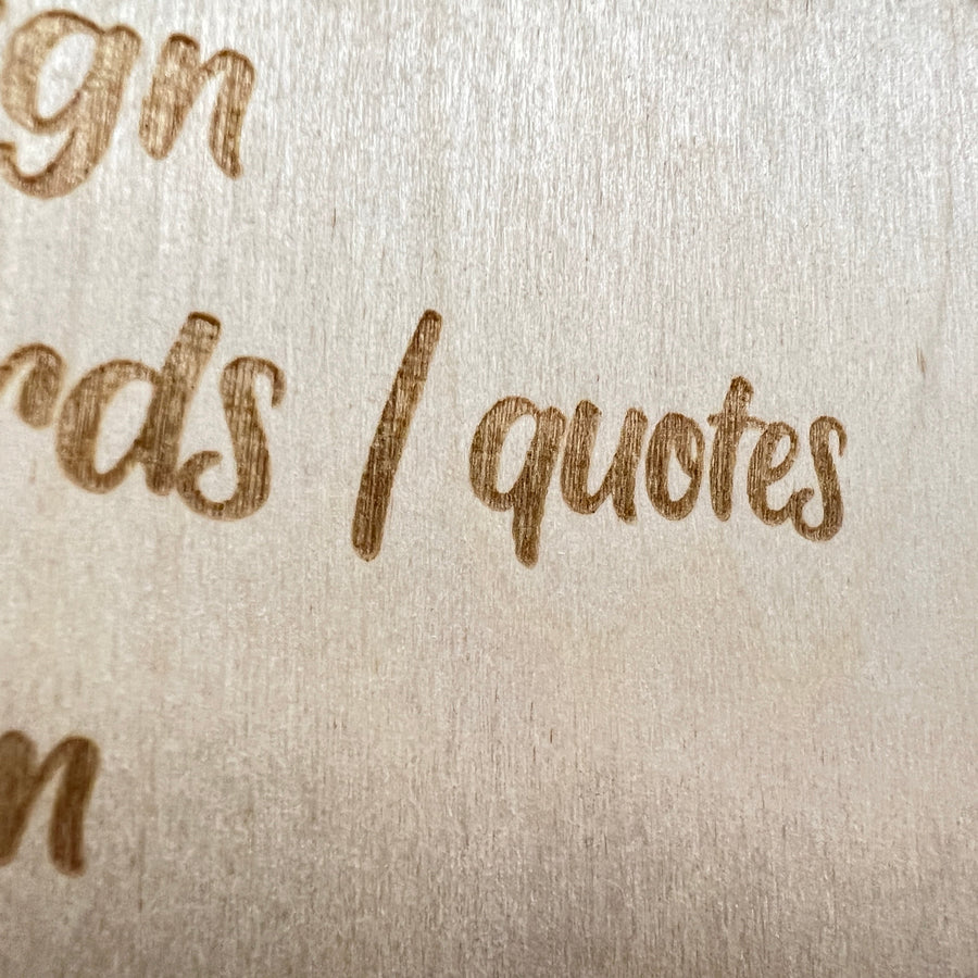 Close-up of engraved script lettering on a large wooden sign