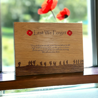 Oak remembrance plaque displayed on a windowsill with poppies behind