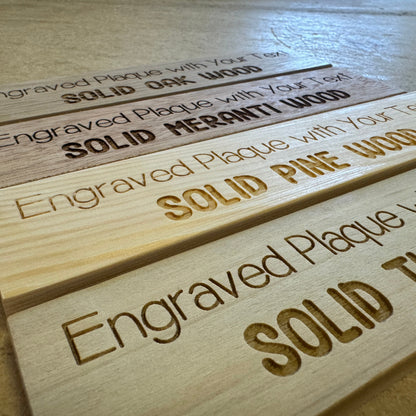 Angled view of engraved wooden plaques in four wood types