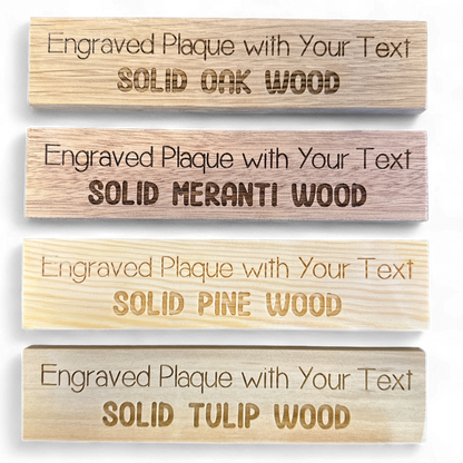 Comparison of engraved oak, meranti, pine and tulipwood plaques on a dark background