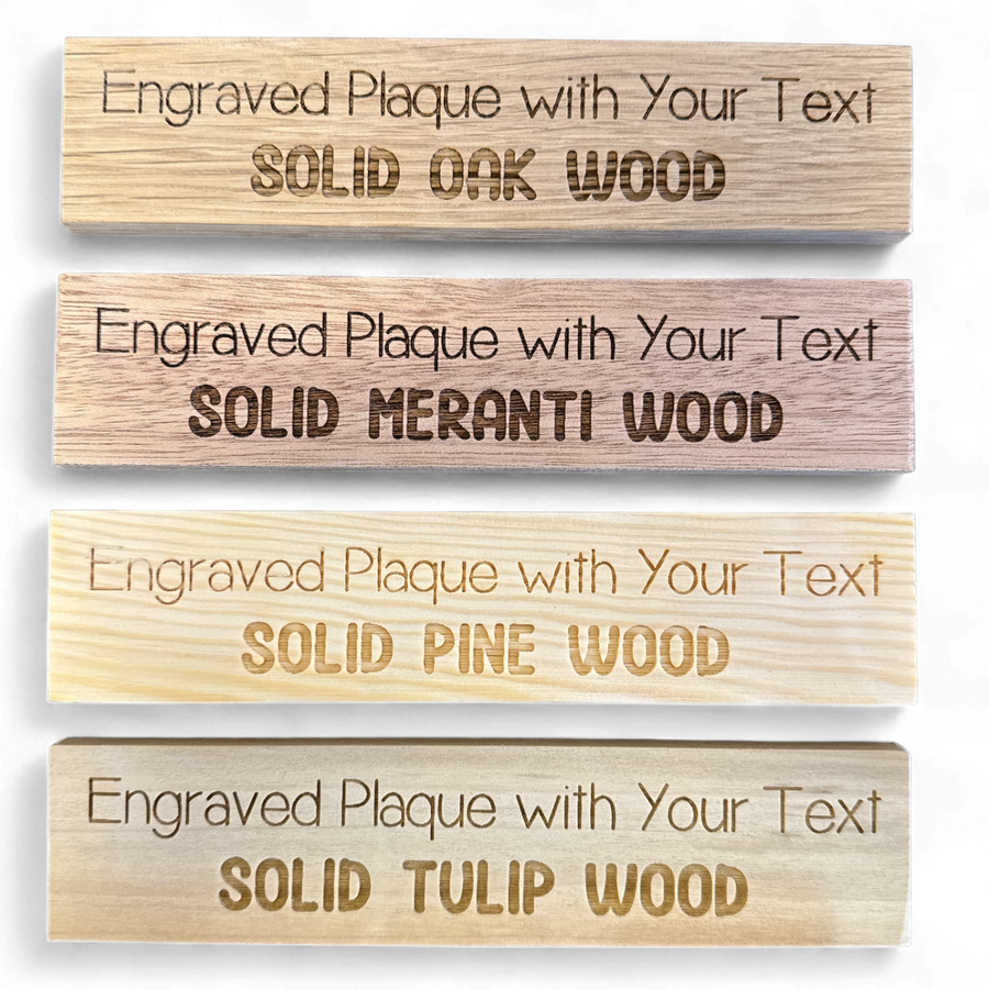 Comparison of engraved oak, meranti, pine and tulipwood plaques on a dark background
