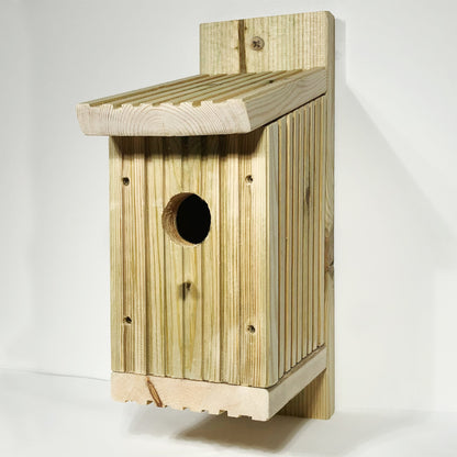 Wooden bird nesting box with a sloping roof and round entrance