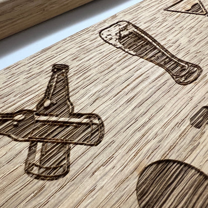 Close-up of beer-glass and crossed cricket-bat clipart engraved in oak