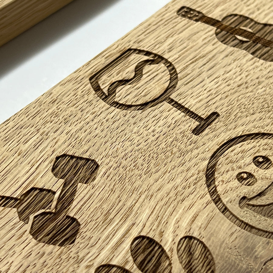Engraved wine-glass, cocktail and smiley-face clipart on an oak plaque