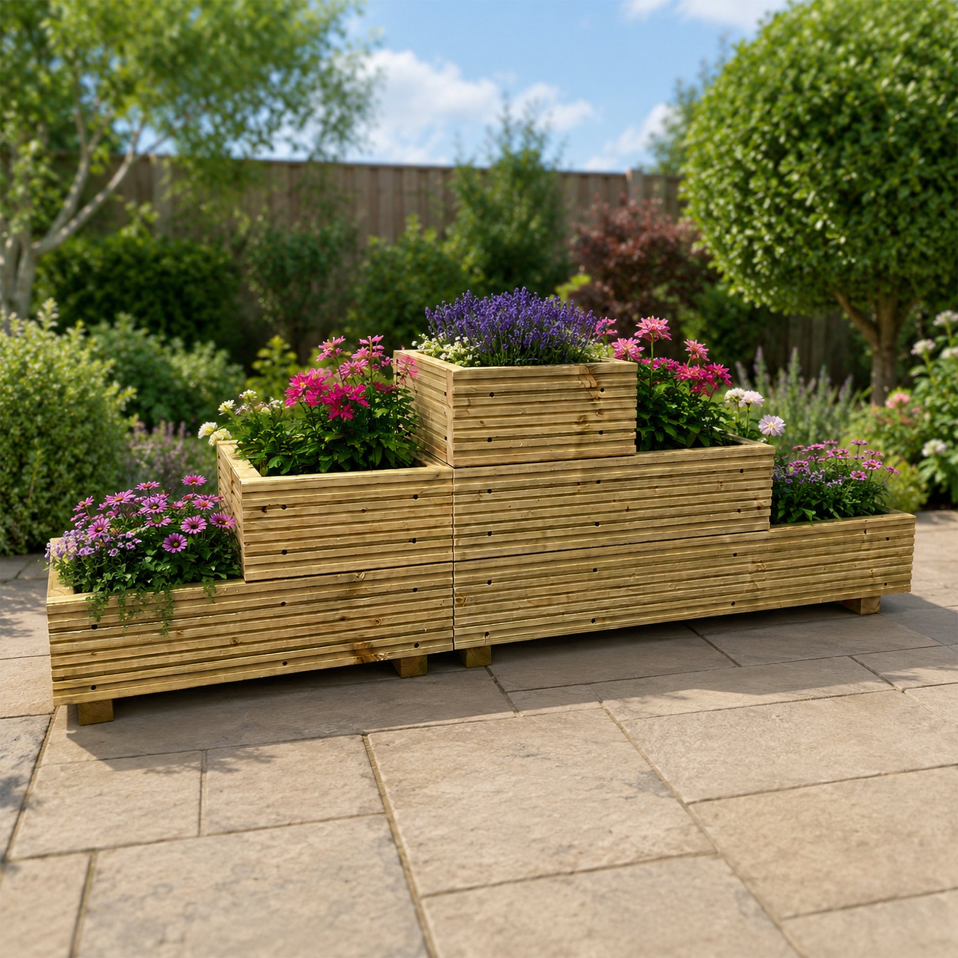 Three-tier straight wooden garden planter filled with purple and pink flowers on a stone patio